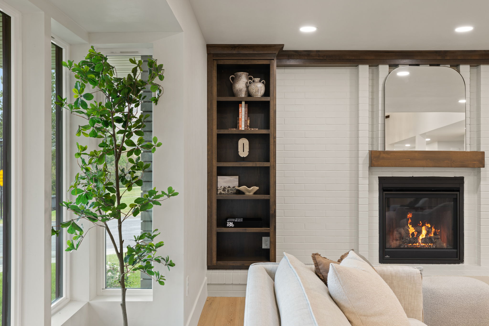 Integrated fireplace with a wood-finish mantel and an arched mirror