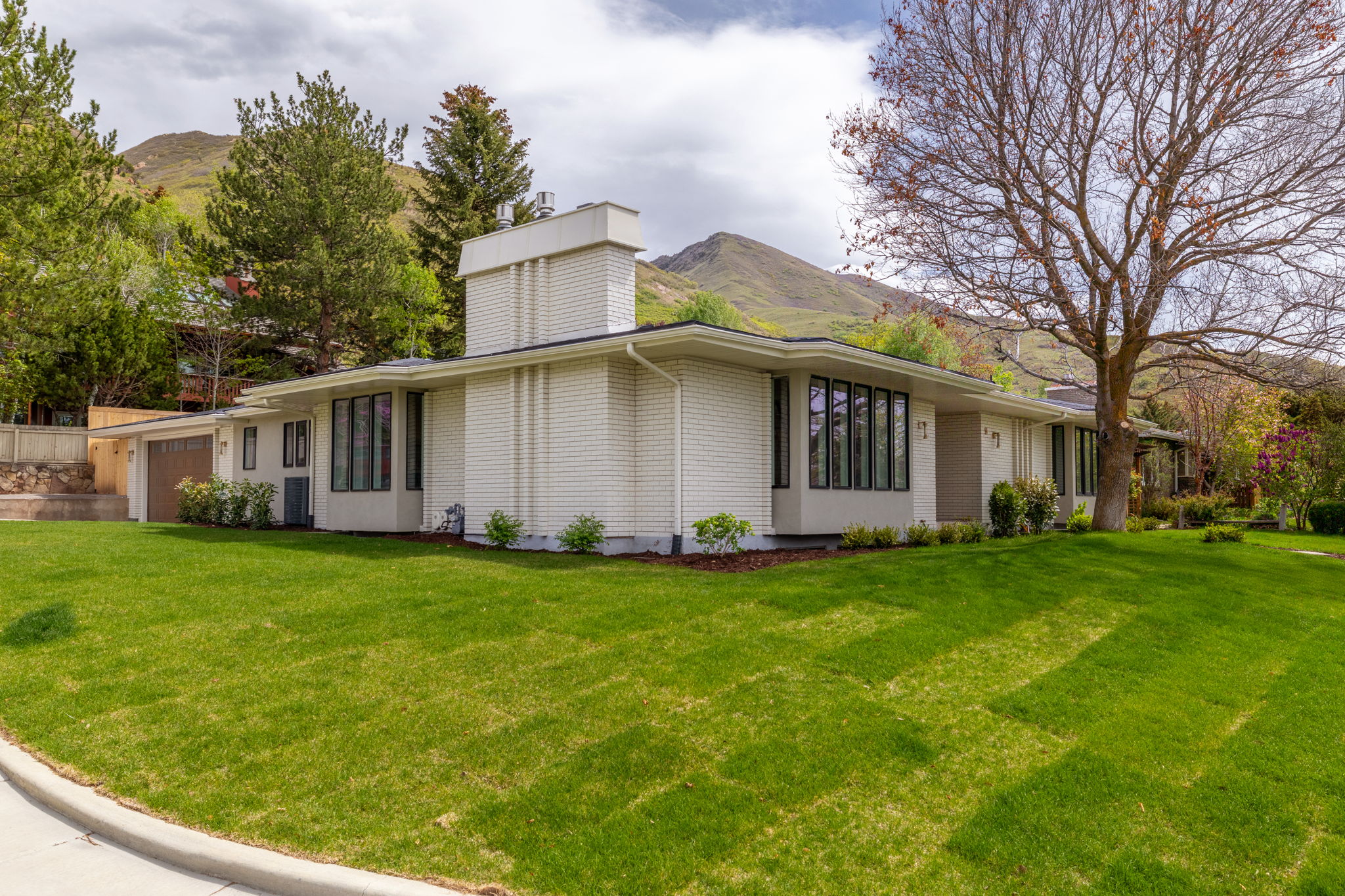 Mid-century modern residence featuring a white brick exterior and a prominent chimney