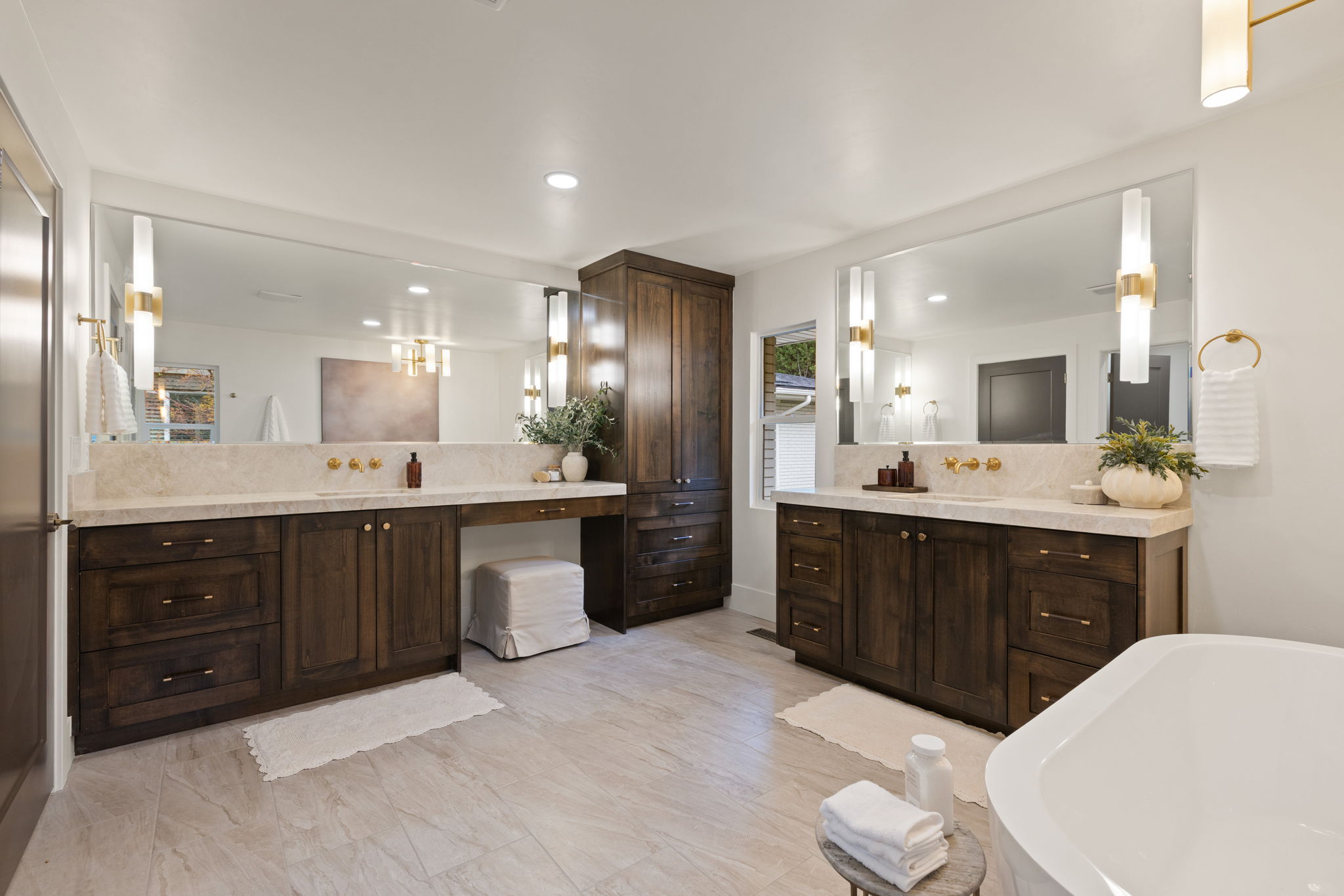 Dual wood-finish vanities with light-toned countertops and integrated sinks