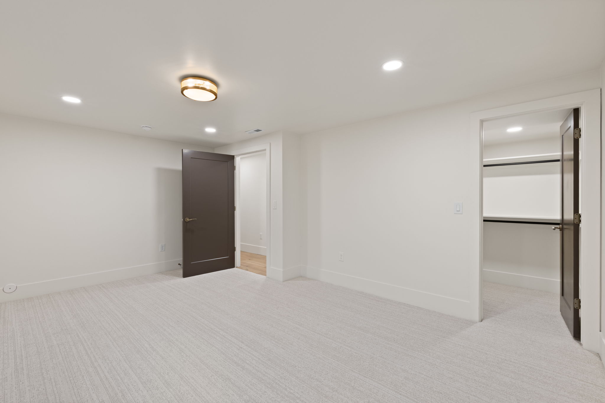 Spacious room featuring light-toned carpet flooring and white walls