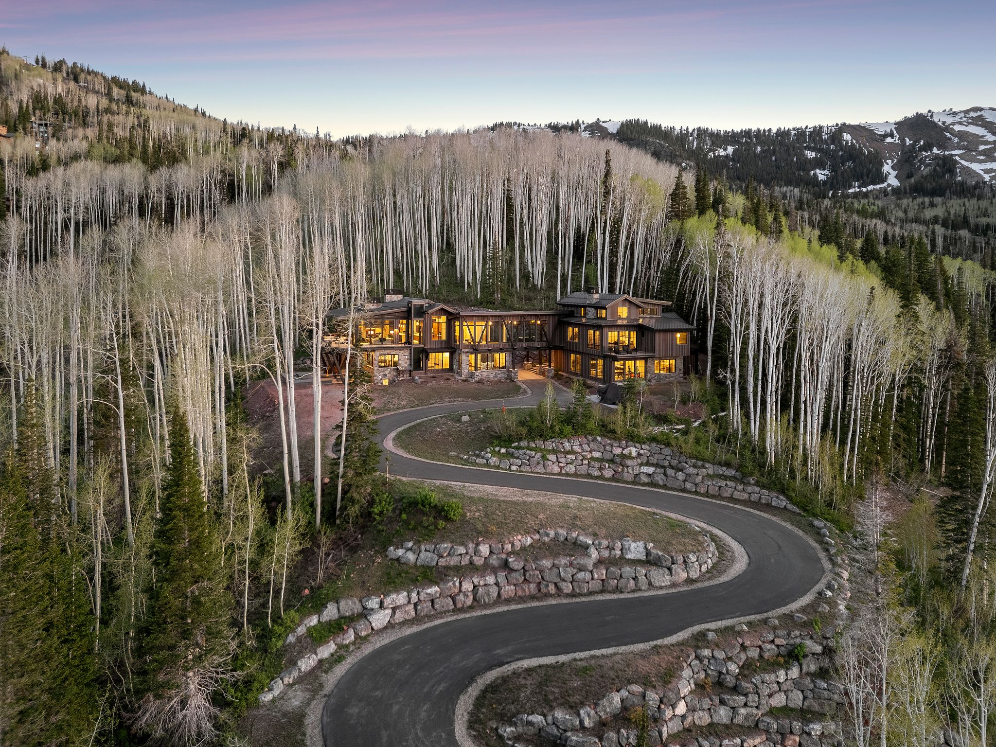 Mountain modern residence featuring dark wood siding and extensive window walls