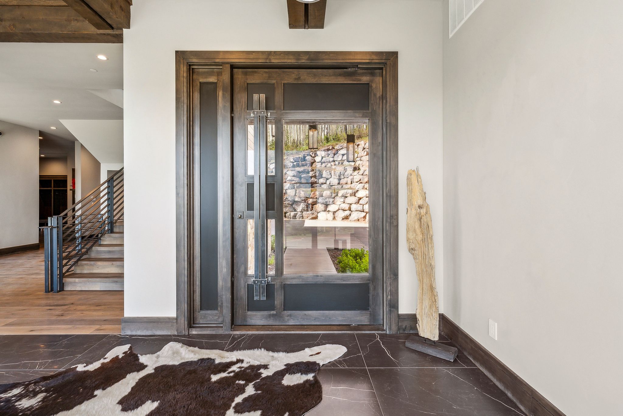 Grand entry featuring a solid wood door with glass paneling, sidelight, and transom window