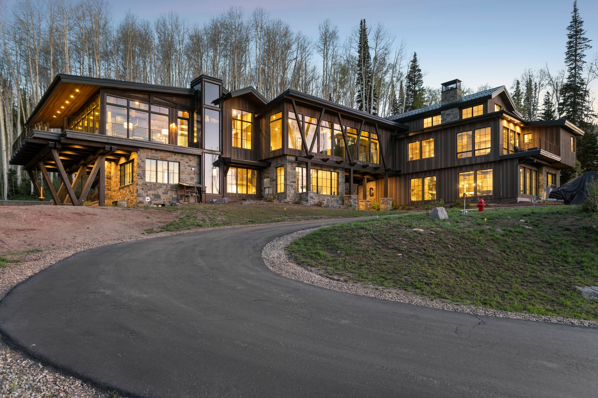 Custom-built residence featuring extensive stonework, wood siding, and prominent exposed beams