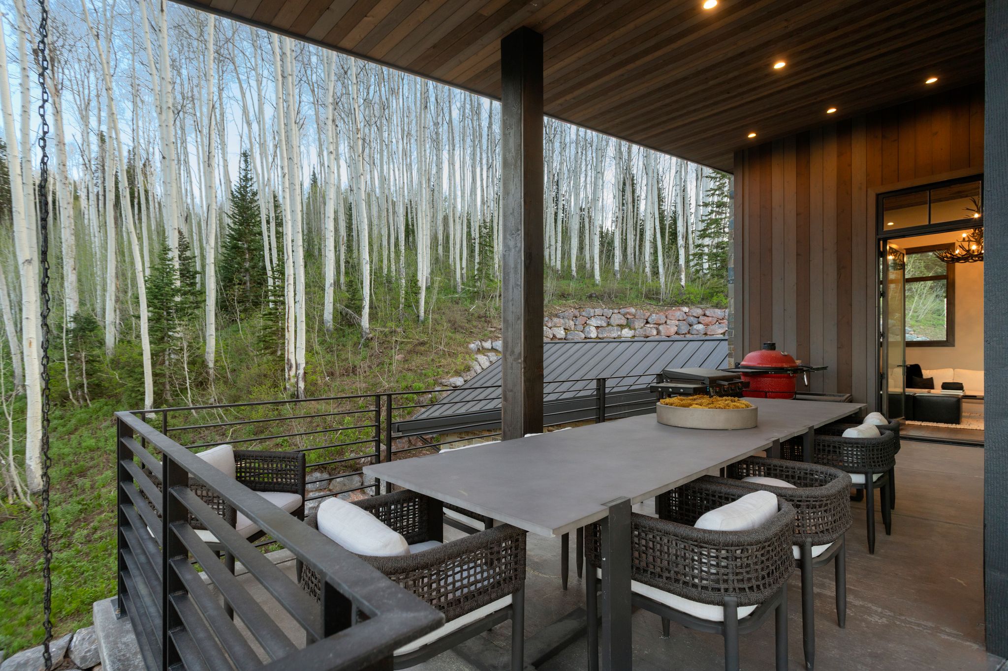 Covered outdoor patio with a plank wood ceiling, recessed lighting, and a dark wood-finish accent wall
