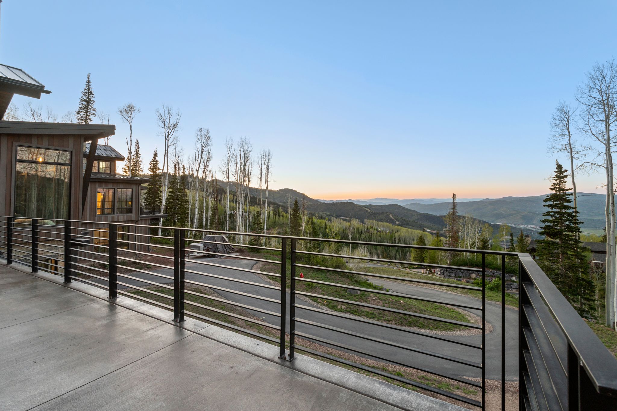 Expansive concrete deck featuring a modern horizontal cable railing system