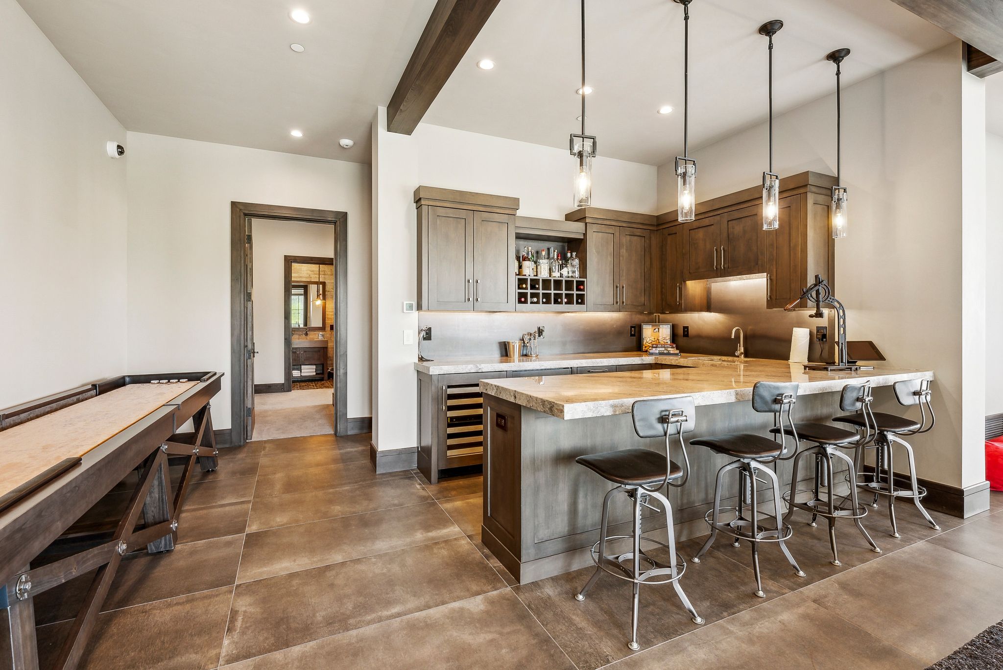 Custom wet bar featuring wood cabinetry, stone countertops, and a built-in wine cooler