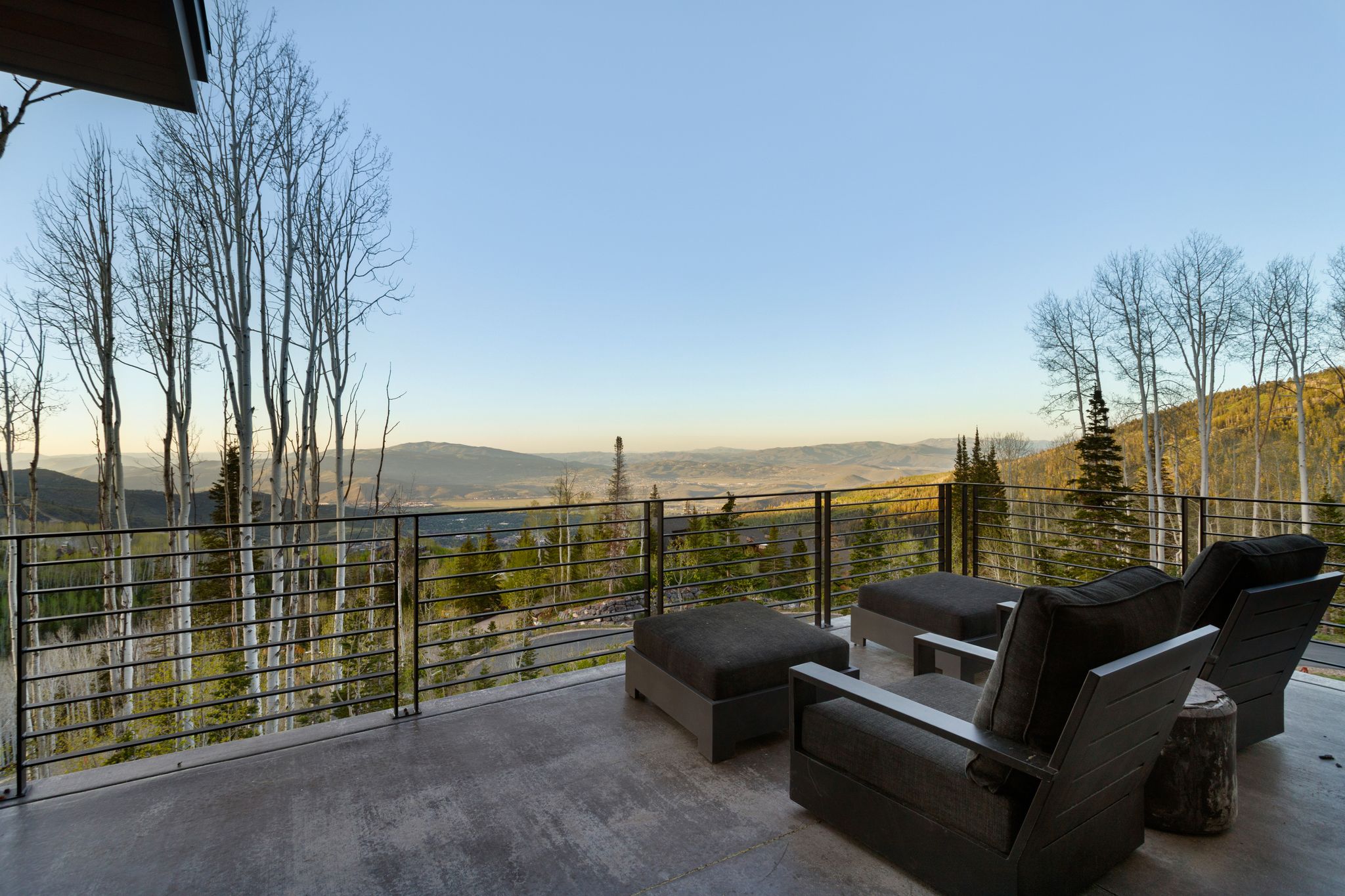 Expansive outdoor deck featuring a concrete surface and horizontal metal railings