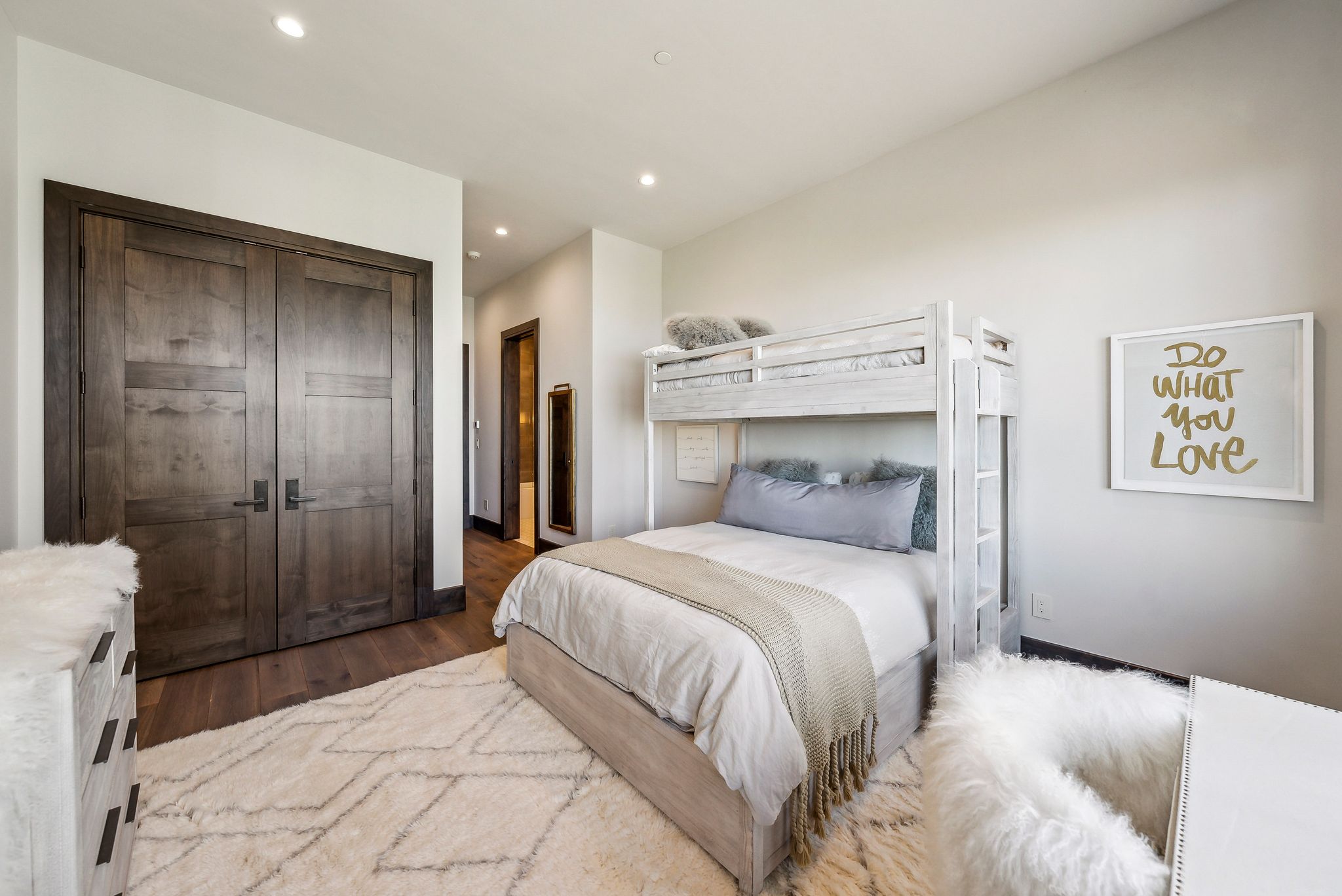 Bedroom featuring recessed lighting, wood-finish flooring, and a double-door closet with dark hardware