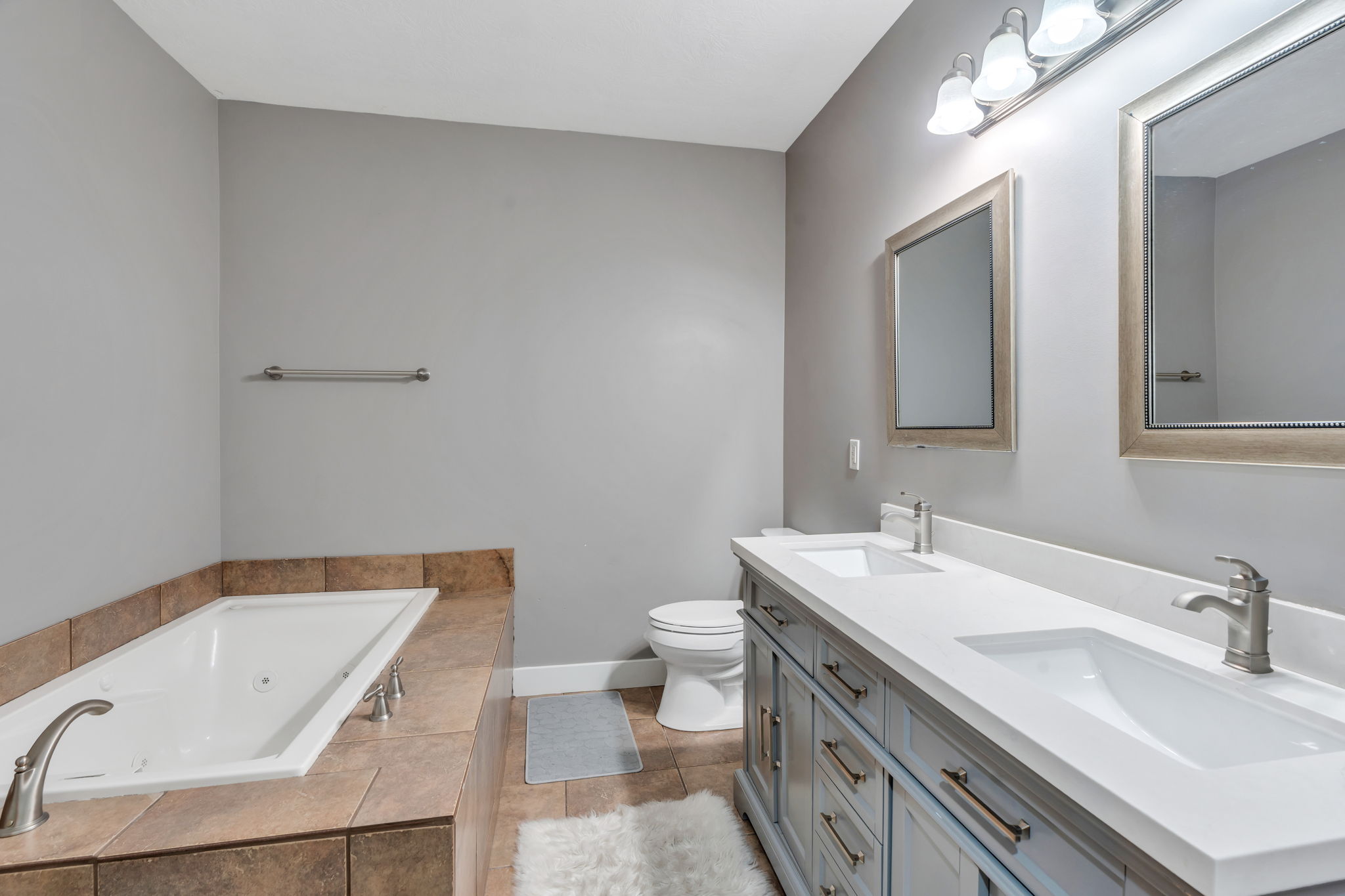 Full bathroom with a jetted tub, and double vanity