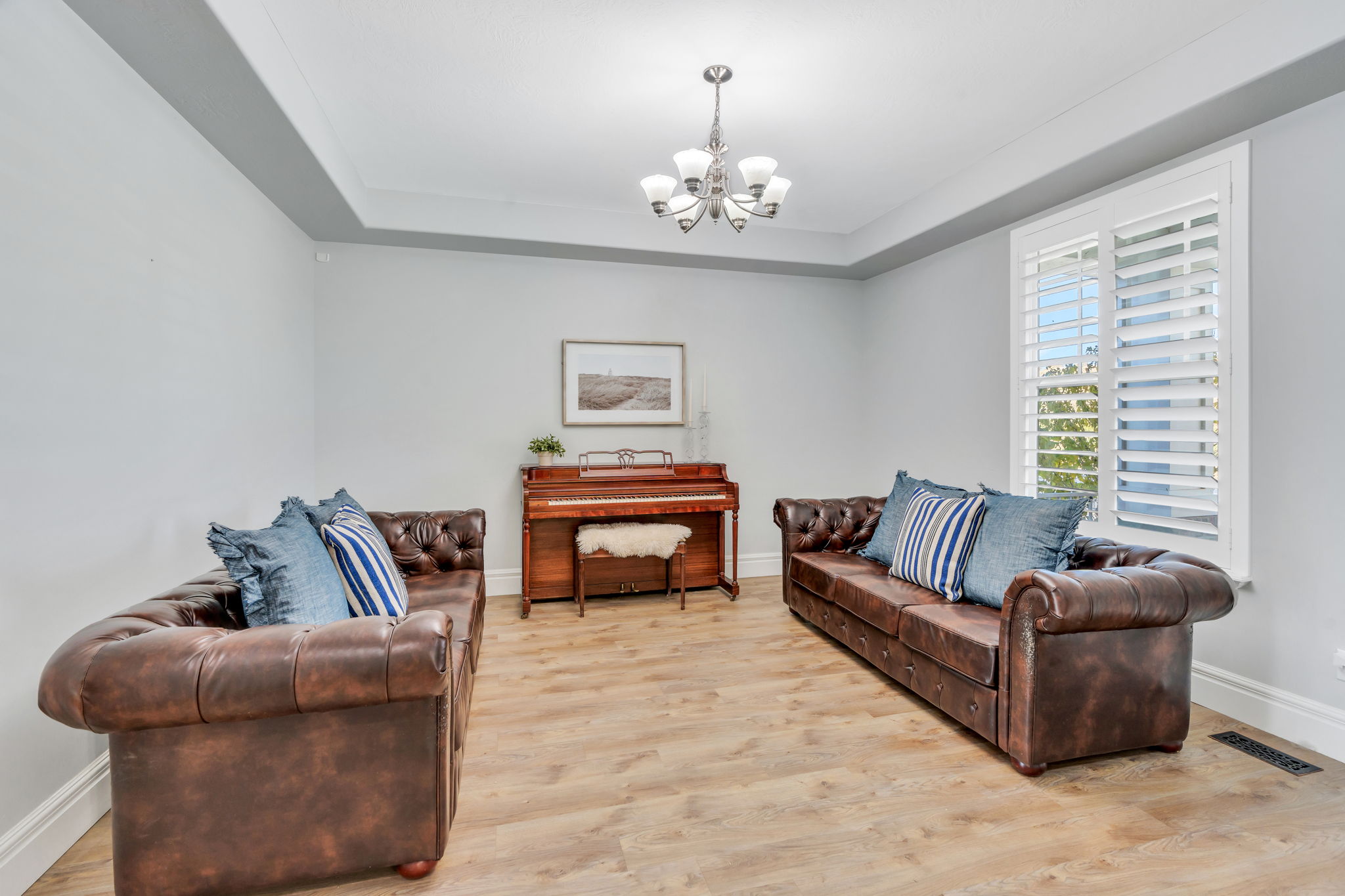 Formal living room with light LVP floors, and a raised ceiling