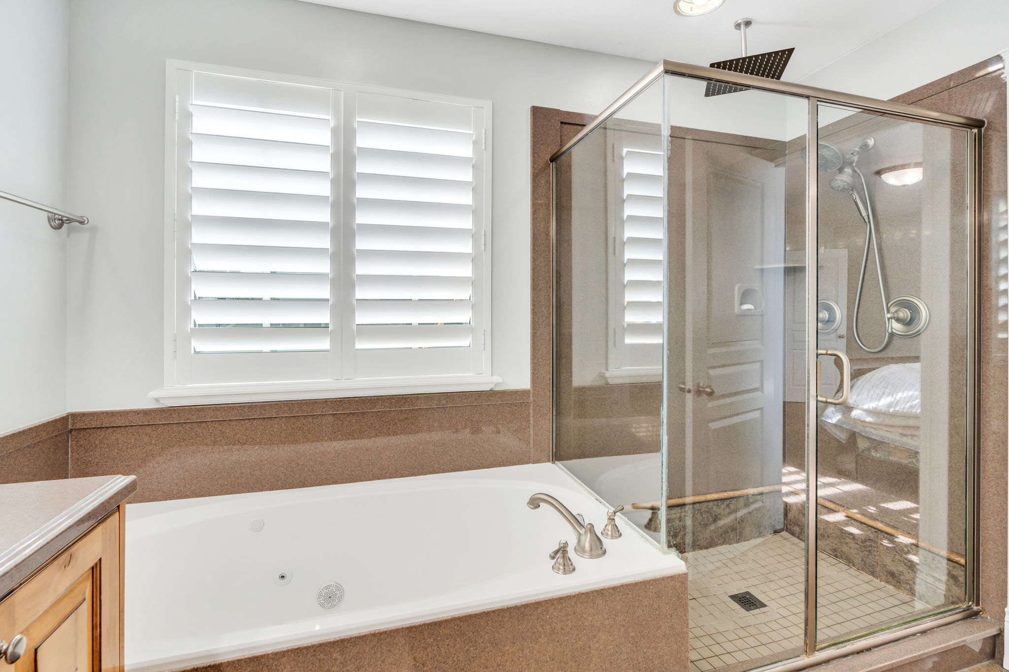 Ensuite bathroom with glass enclosed shower and jetted tub