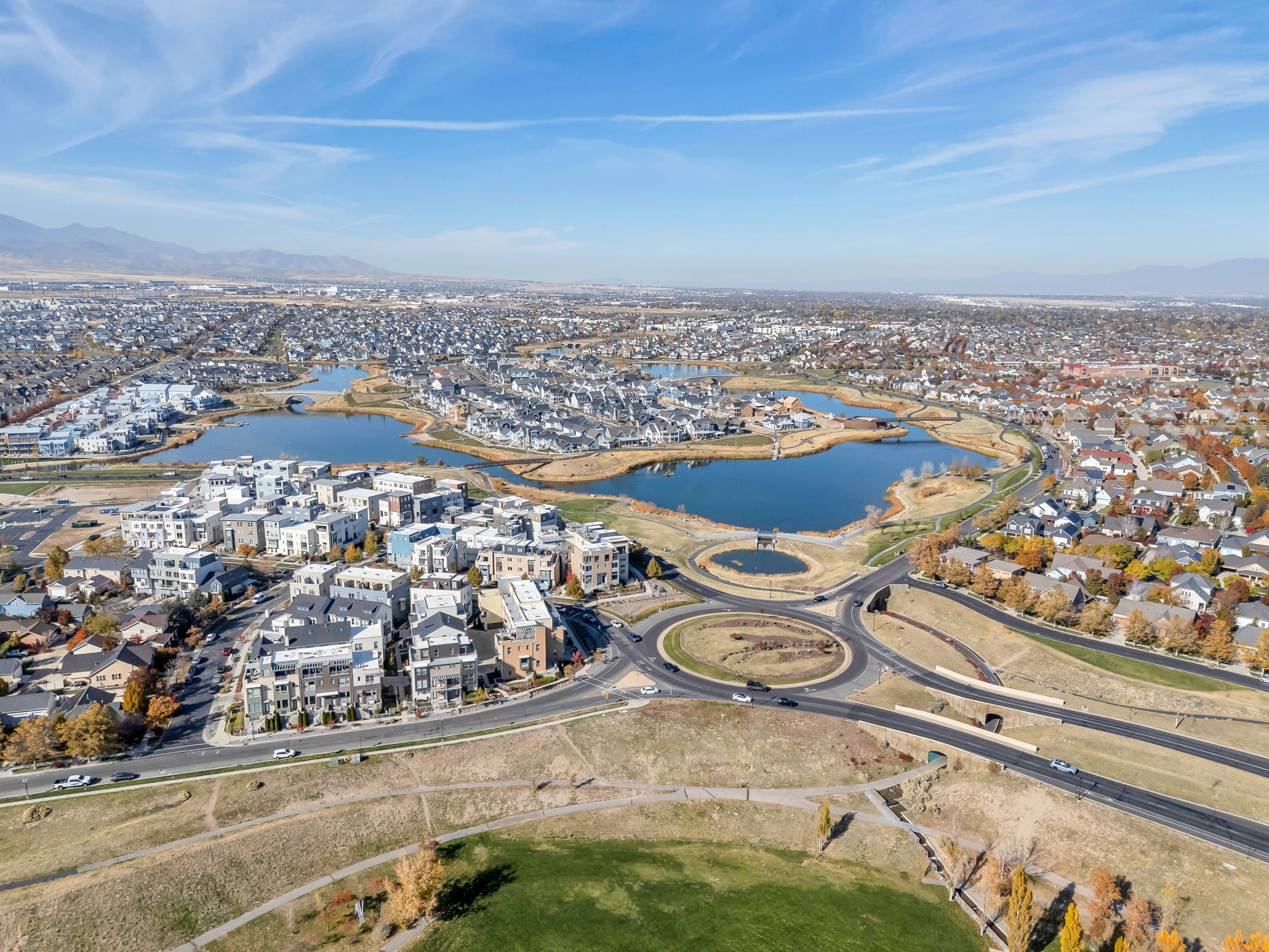 Aerial view of Oquirrh Lake and surrounding suburban area with mountain views