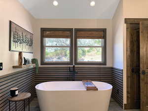 Freestanding soaking tub with dark-finish floor-mounted faucet