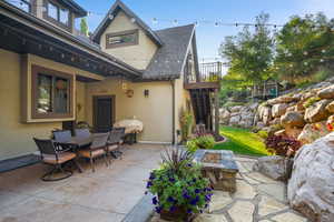 Patio area featuring a built-in fire pit with stone accents, a flagstone walkway, and a landscaped retaining wall