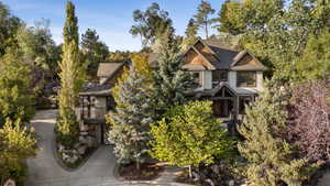 Exterior featuring a split-gable roof, cedar shake siding accents, and a stone facade