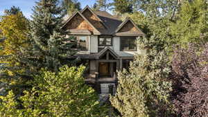 Custom home featuring a prominent gabled roofline, cedar shake siding accents, and a covered entry with timber frame details