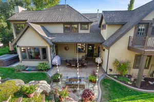 Rear exterior with a covered patio and stone fire pit