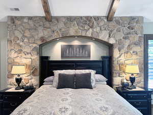 Stone accent wall featuring an arched alcove with recessed lighting