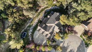 Contemporary residence featuring a multi-gabled roofline and extensive mature landscaping