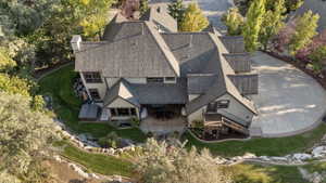 Spacious property with a multi-level roofline, extensive paved driveway, and mature landscaping