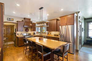 Kitchen featuring wood-finish flooring, recessed lighting, and a multi-light linear chandelier