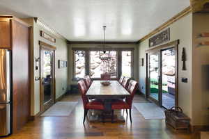 Dining area featuring wood-finish flooring, two glass-paned doors with wood frames, and a prominent wood dining table
