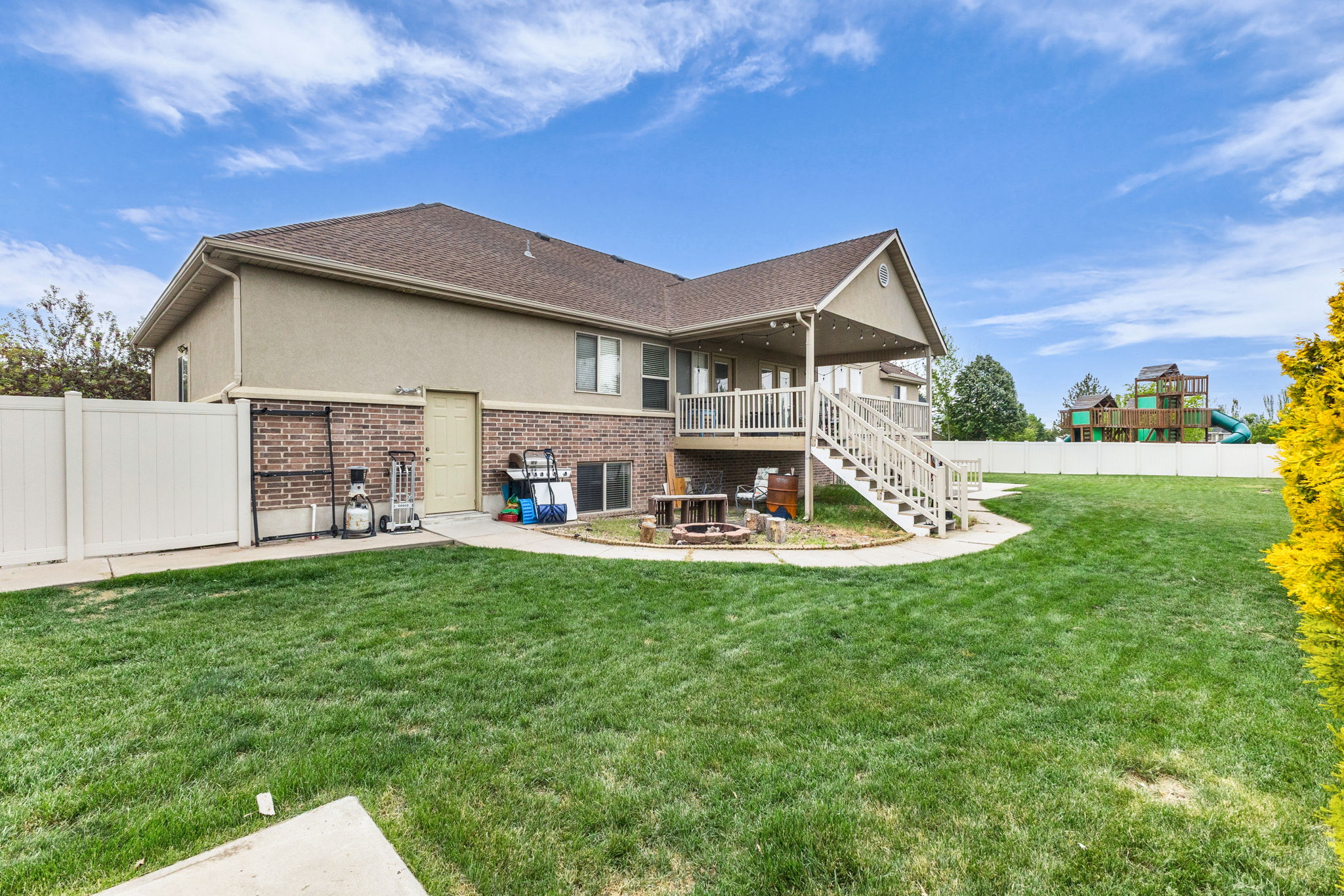 Expansive green lawn with a white privacy fence