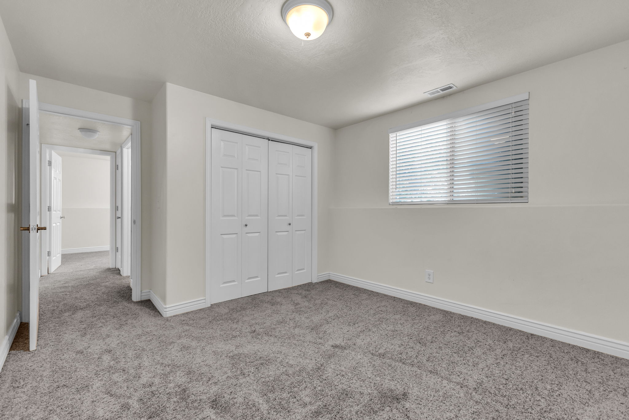 Neutral wall paint throughout this carpeted room