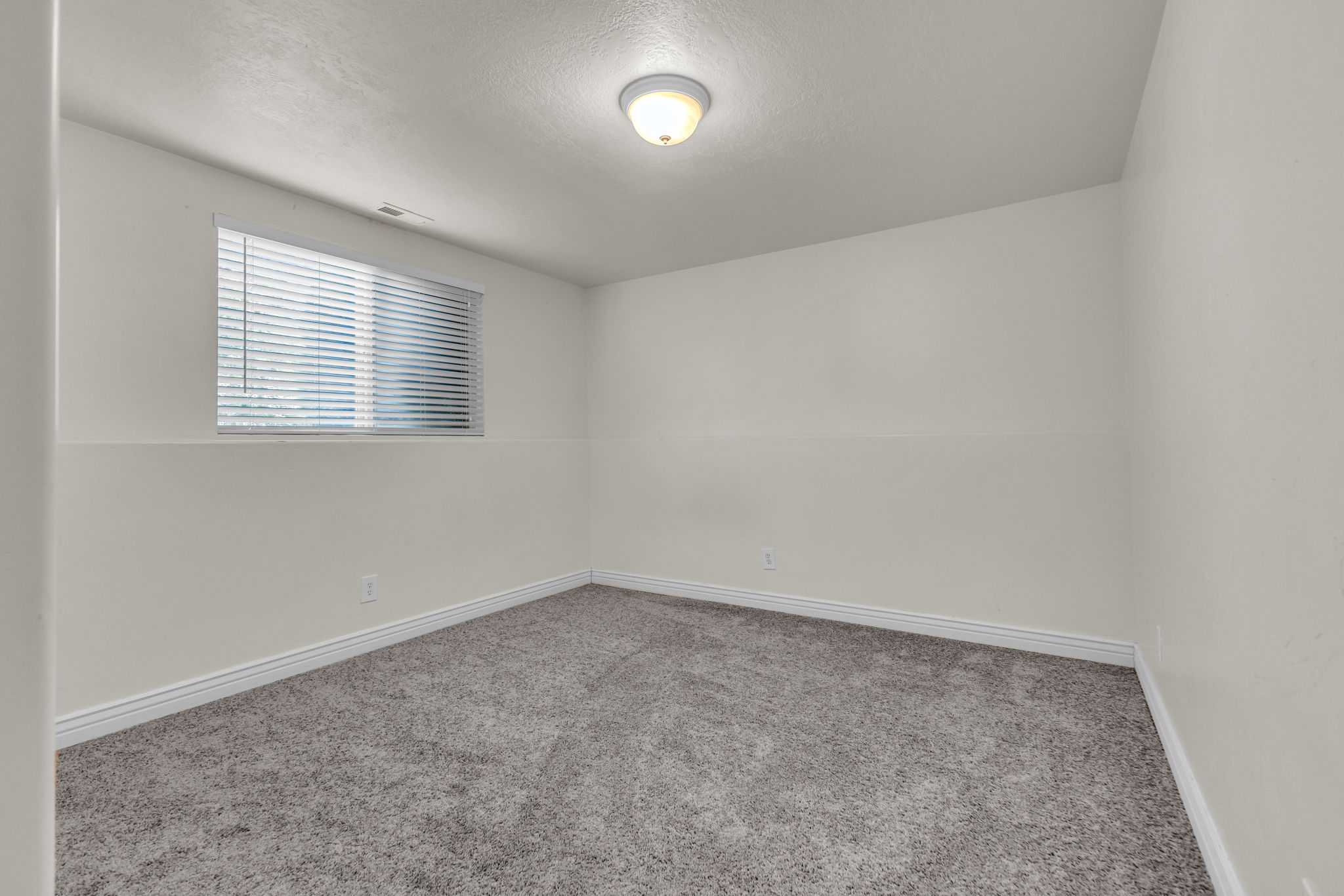 Neutral-toned walls complement the gray carpeting