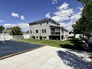 Spacious backyard featuring a screened-in porch, manicured lawn, concrete patio, and privacy fencing