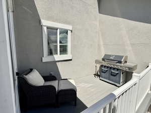 Outdoor deck featuring a white railing and a window with white trim