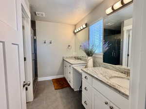 Dual vanity countertops with integrated sinks and wall-mounted lighting