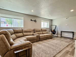 Expansive living area featuring light gray walls, recessed ceiling lighting, and two large windows