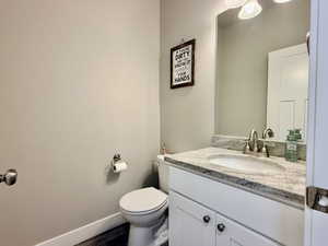 Vanity with a light-colored countertop and integrated sink, brushed nickel faucet, and overhead three-bulb light fixture