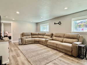 Spacious room featuring wood-finish flooring, recessed lighting, and light-toned walls