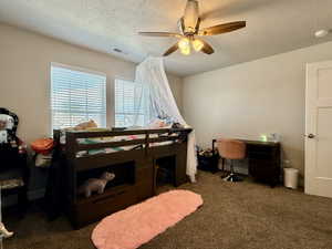 Spacious room featuring neutral-toned walls, textured carpeting, and a wood-finish ceiling fan with integrated lighting