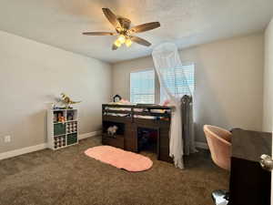 Bedroom featuring neutral wall paint, textured carpeting, a ceiling fan with integrated lighting, and window blinds