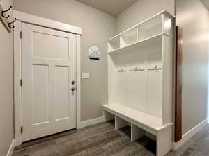 Entryway featuring a built-in white storage bench with integrated shelving and coat hooks