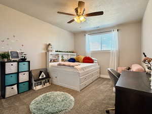 Carpeted room featuring a ceiling fan with integrated lighting, a window with blinds and sheer curtains, and light-toned wall paint