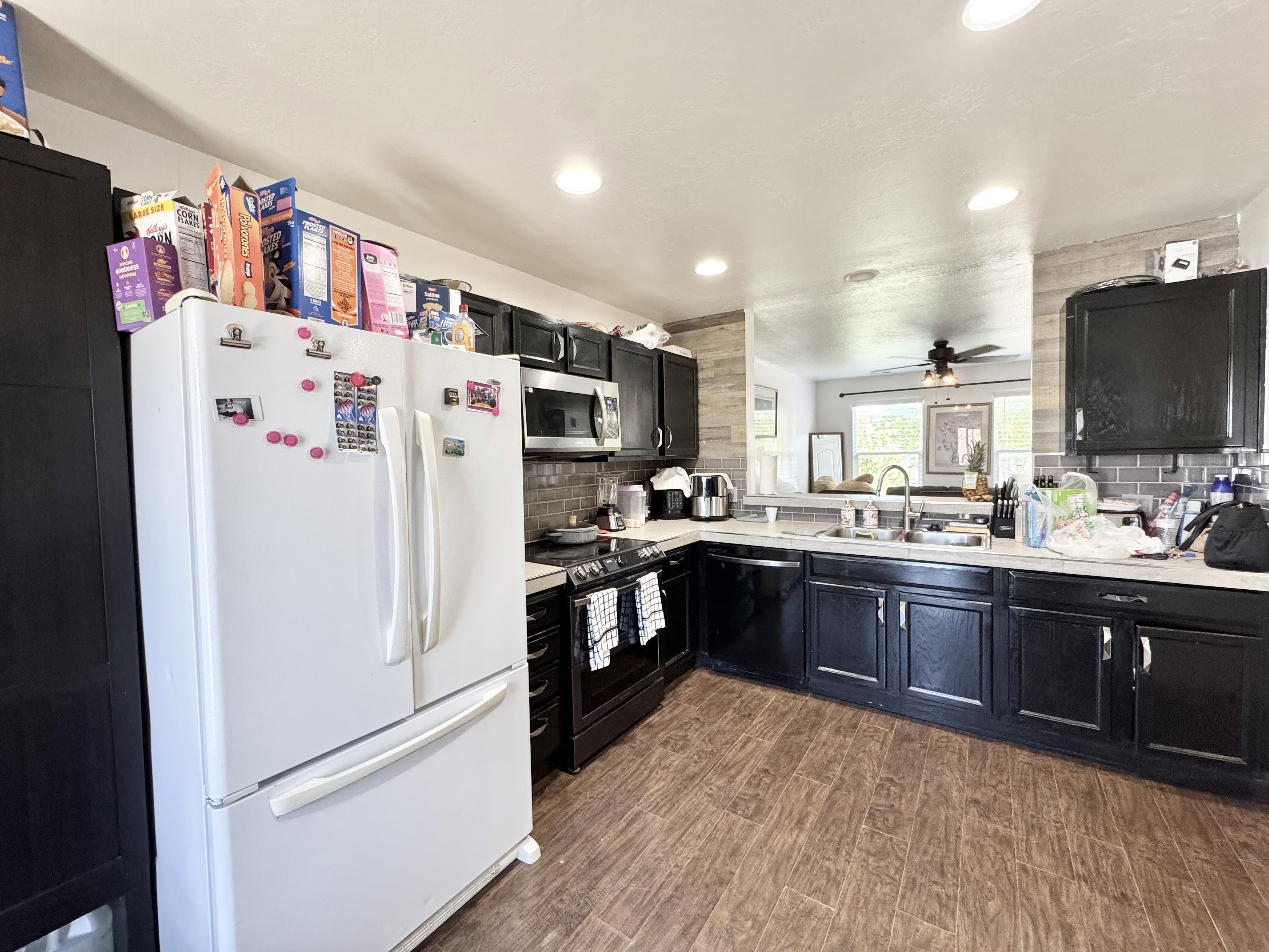 Kitchen featuring dark cabinetry with brushed nickel hardware, wood-finish flooring, and recessed ceiling lighting