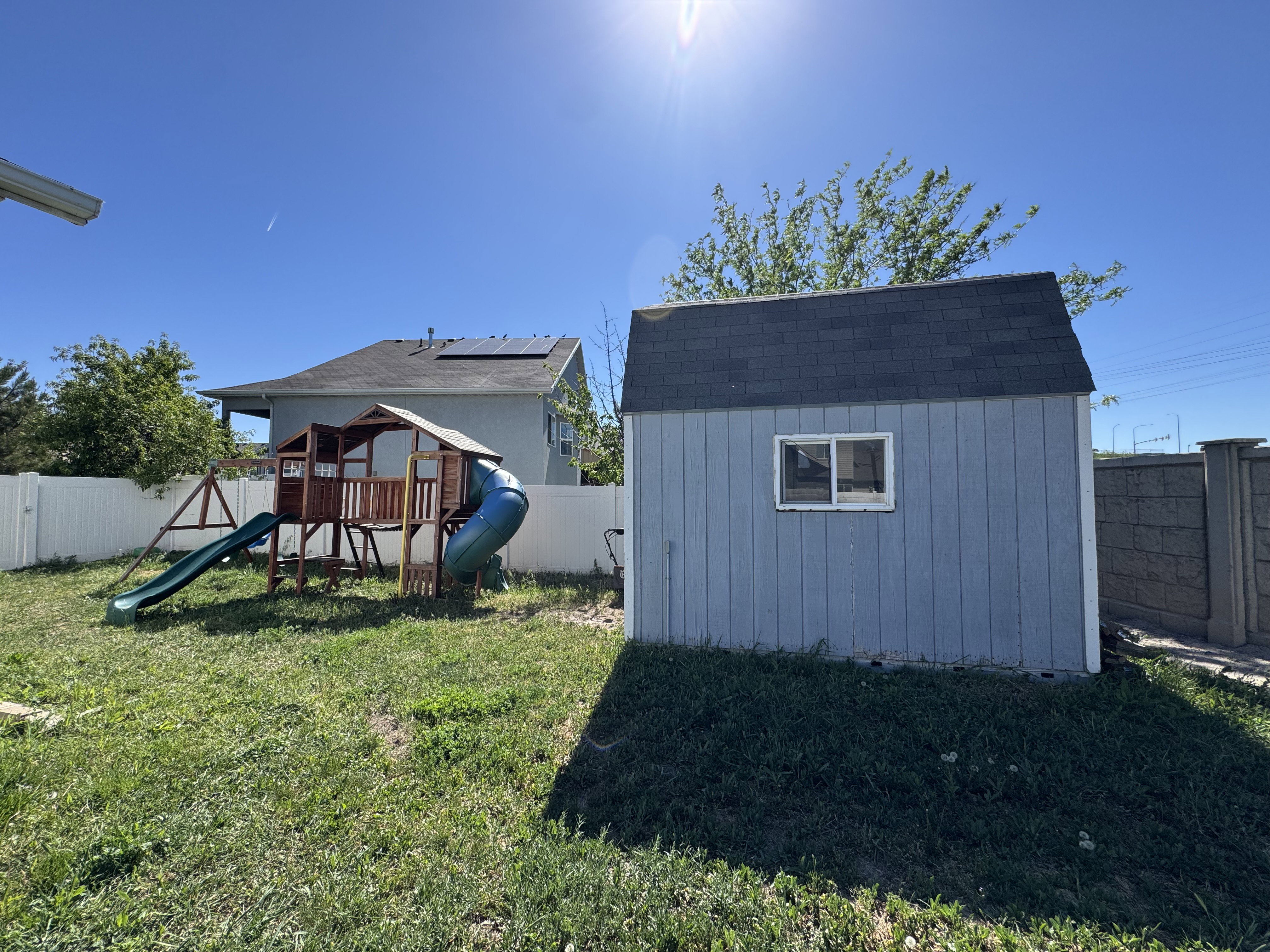 Utility shed with blue siding and a dark shingled roof, featuring a single window