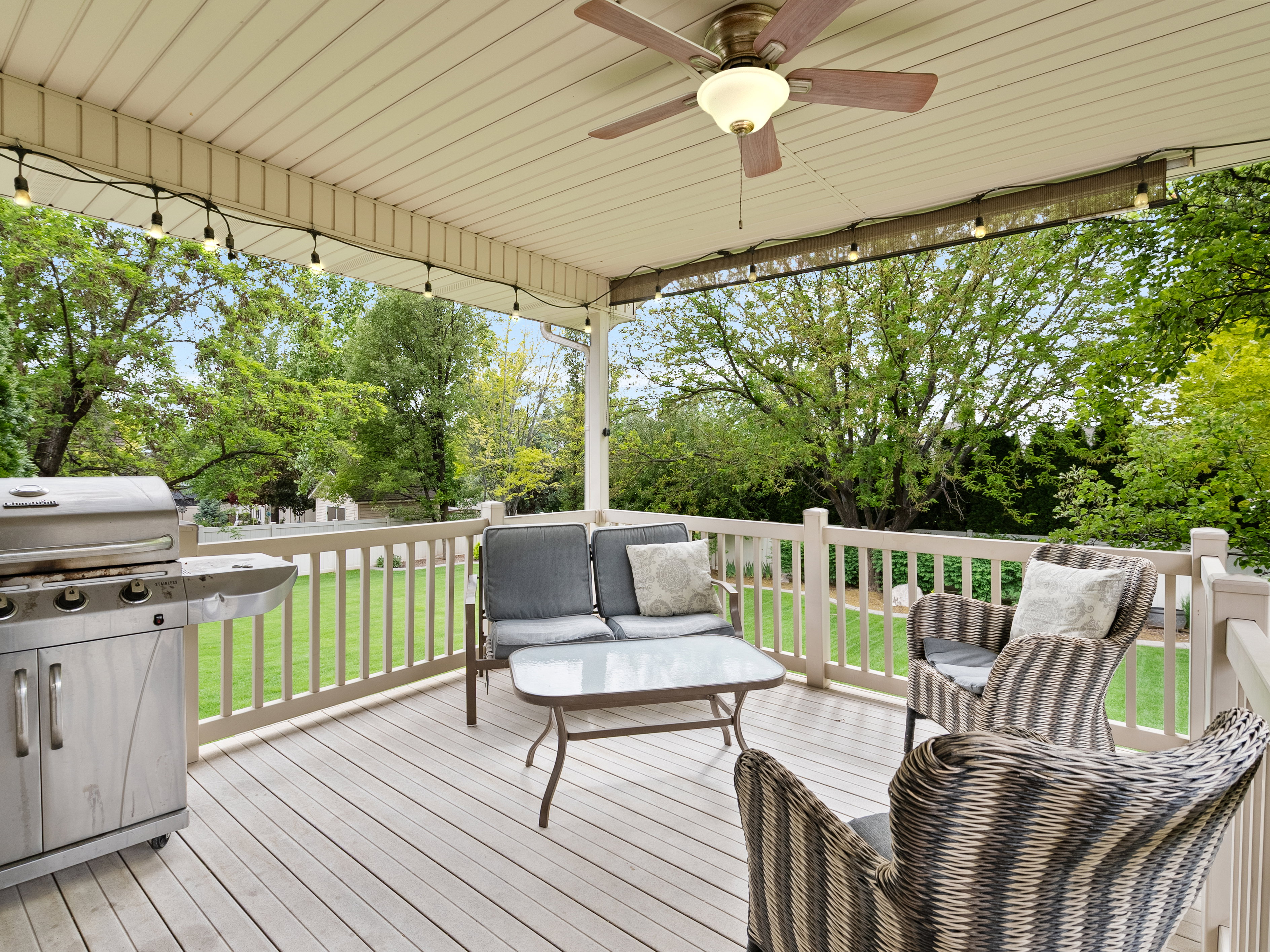 Spacious deck featuring wood-finish flooring, a built-in ceiling fan, and string lighting