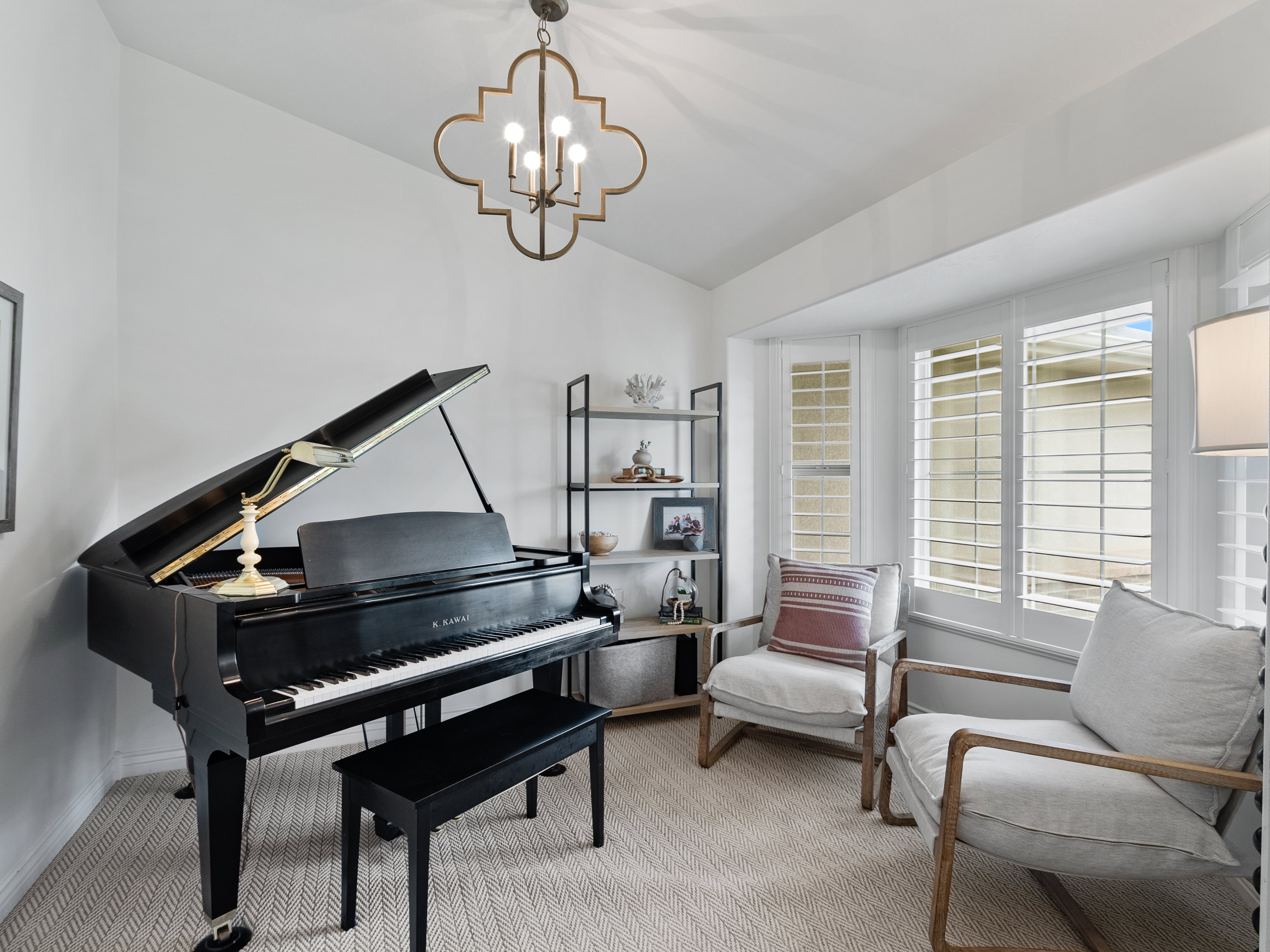 Bay window with white plantation shutters and light-colored carpeting