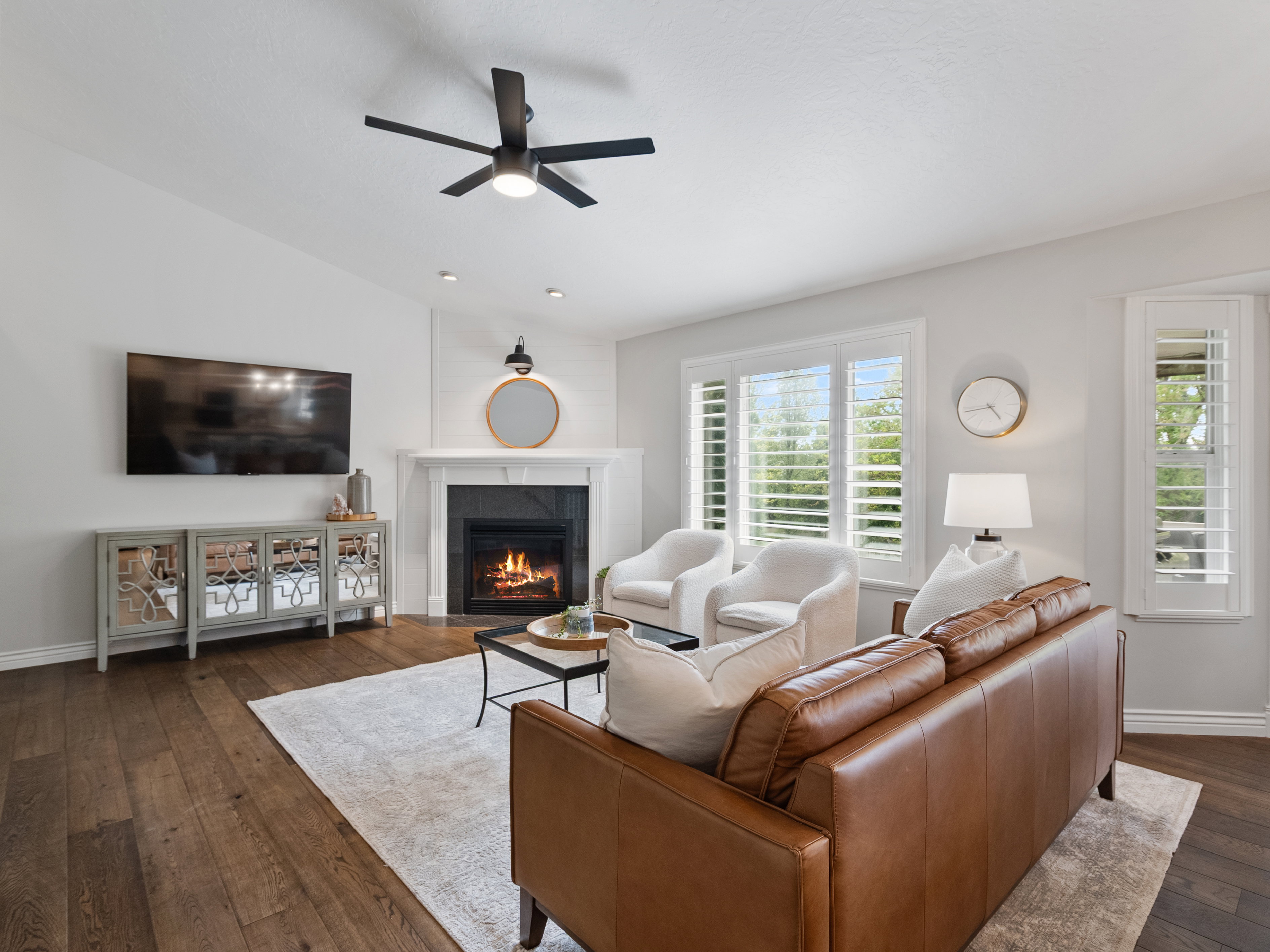Living area featuring wood-finish flooring, a contemporary ceiling fan, and recessed lighting