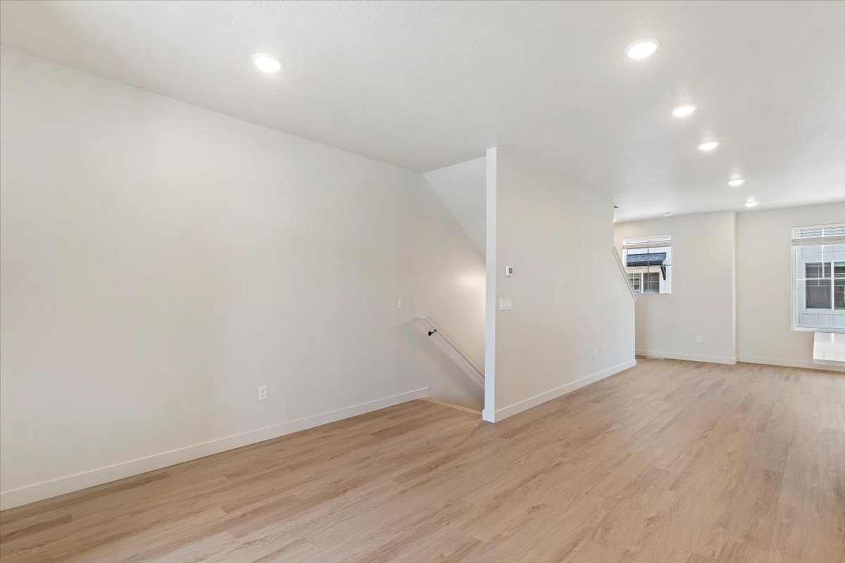 Open concept living space featuring wood-finish flooring, recessed lighting, and white baseboards