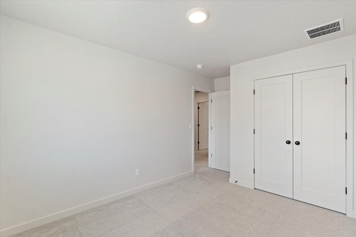 Neutral color palette room with light-toned carpet flooring and white trim