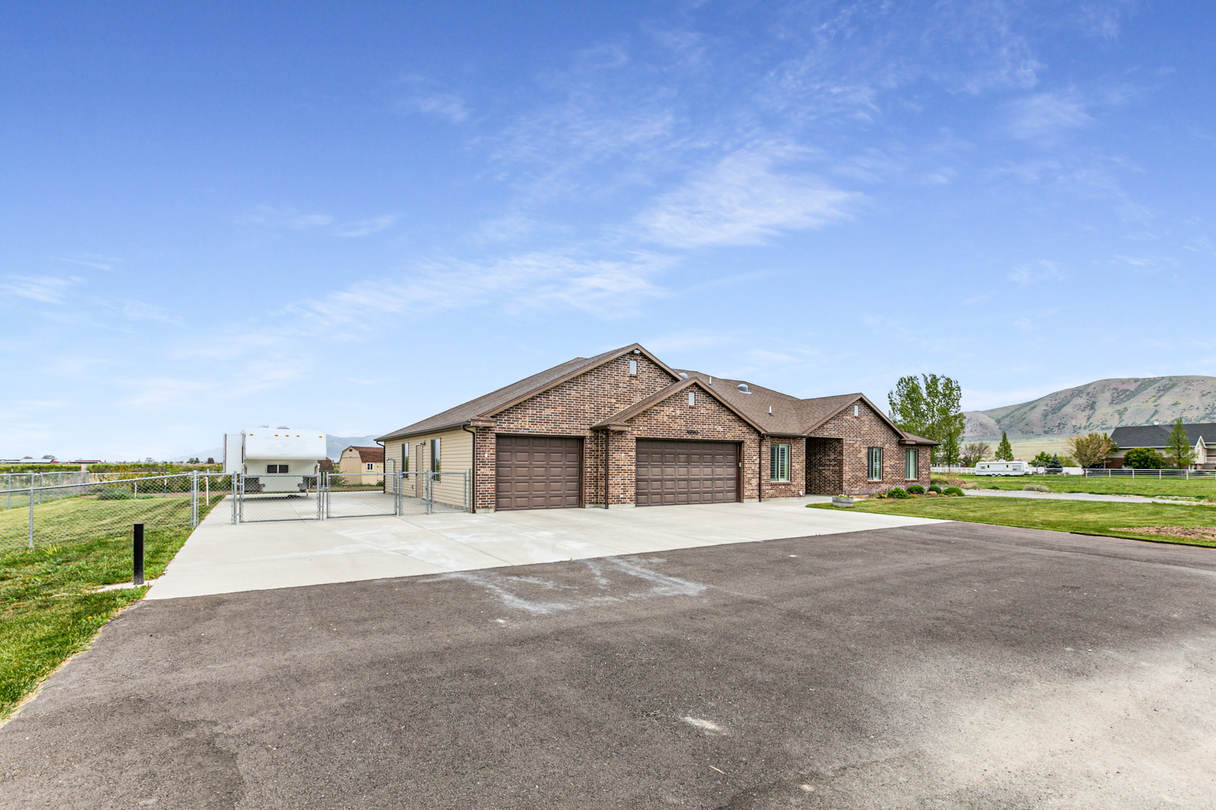 Ranch-style residence featuring a brick facade, integrated two-car garage, and a concrete driveway
