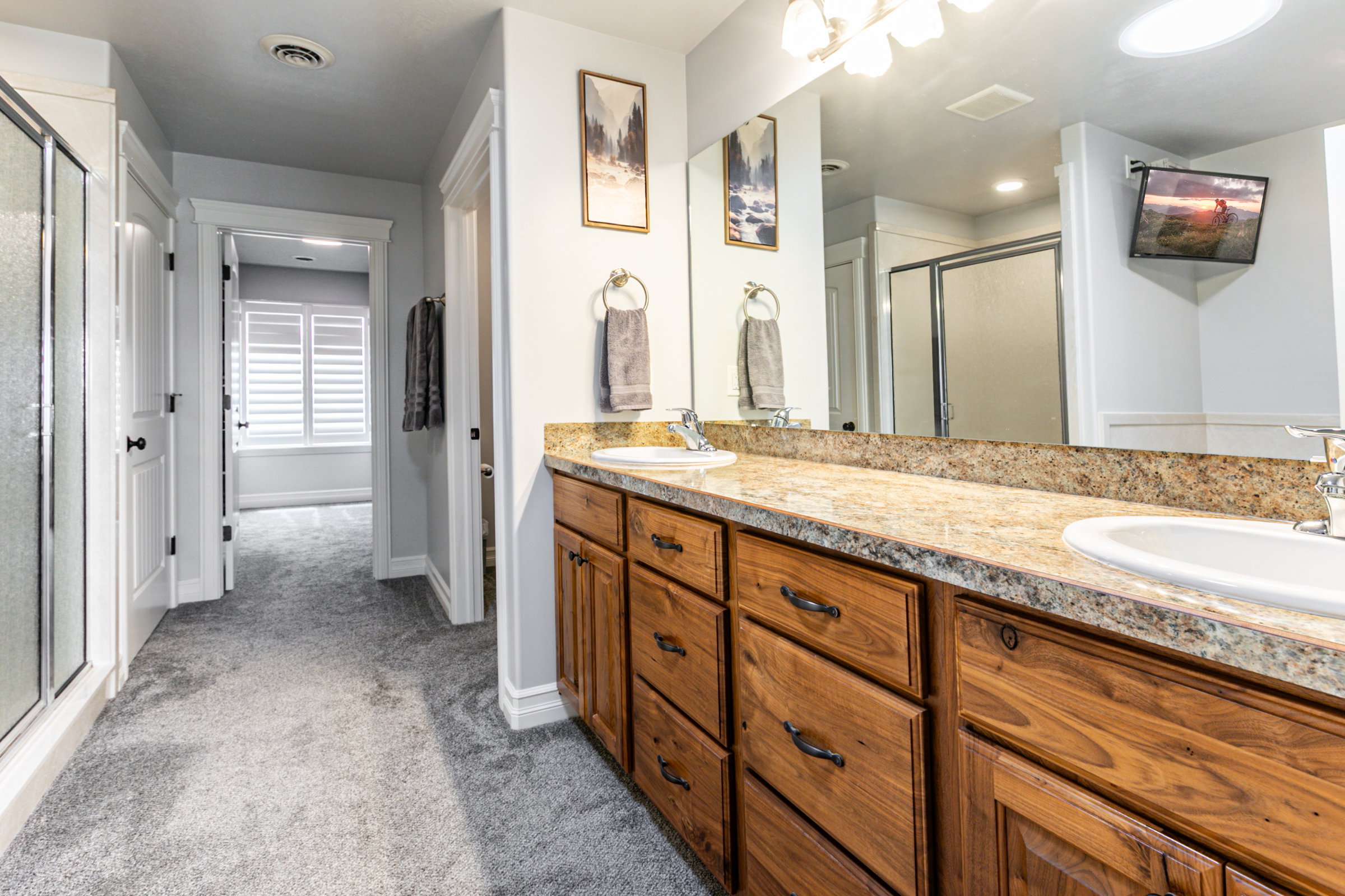 Bathroom featuring a double vanity with wood cabinetry and stone-finish countertops