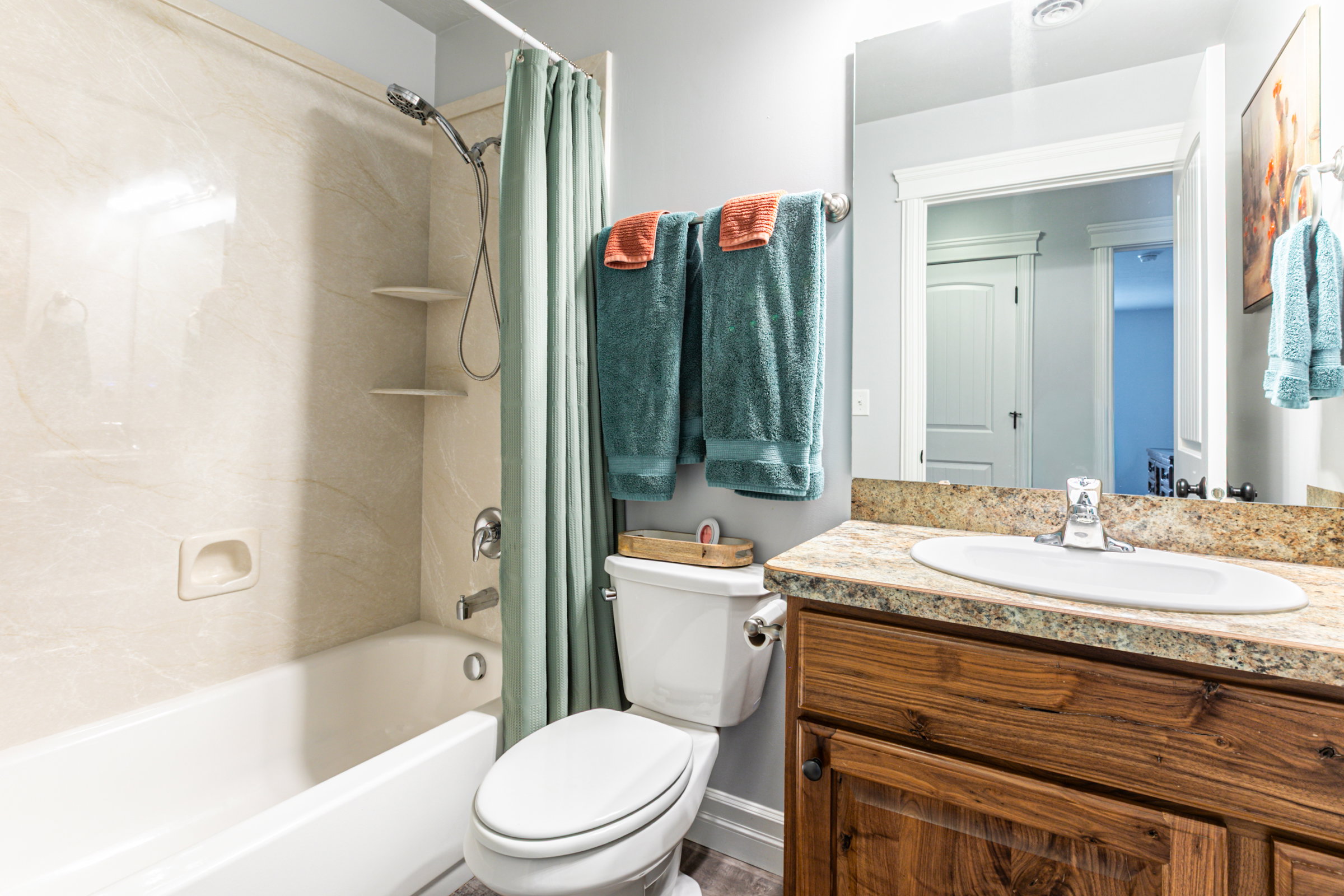 Bathroom featuring a bathtub with a shower kit, a toilet, and a vanity with an integrated sink