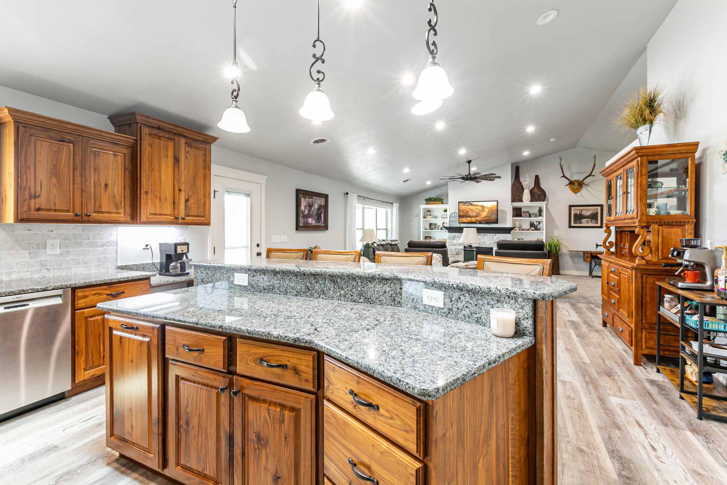 Kitchen island featuring a granite countertop with a raised bar and wood cabinetry